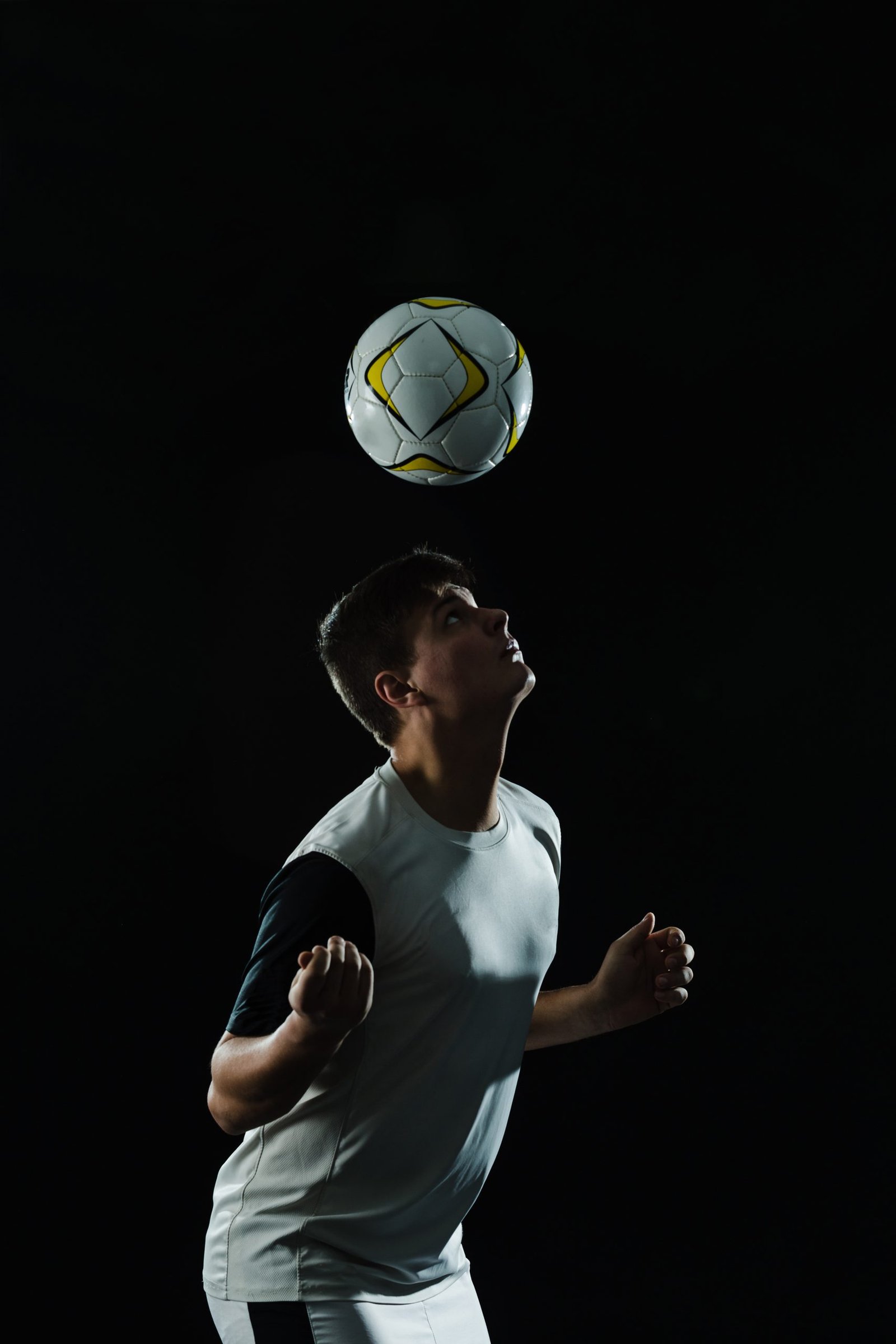 Home soccer player using his head hit ball